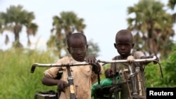 Watoto wakimbizi kutoka Sudan Kusini wanaendesha baiskeli zao katika makazi ya wakimbizi ya Palorinya, Uganda. Oktoba 25, 2017. Picha na REUTERS/James Akena