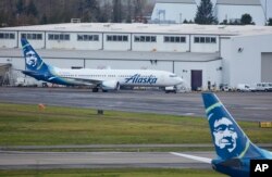 Alaska Airlines N704AL, a 737 Max 9 which made an emergency landing at Portland International Airport after a part of the fuselage broke off mid-flight on Friday, in Portland, Ore., Jan. 6, 2024. (AP Photo/Craig Mitchelldyer)