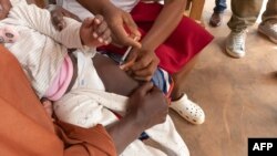 Mhudumu wa afya wakitoa chanjo ya Malaria kwa mtoto huko Cameroon Januari 22, 2024. Picha na ETIENNE NSOM / AFP