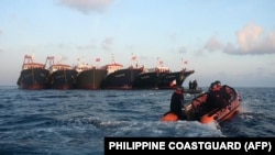 資料照：菲律賓海岸警衛隊發布照片顯示其巡邏艇駛過停泊在南中國海牛軛礁附近的多艘中國船隻。（2021年4月14日）