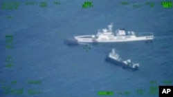 En esta imagen publicada por las Fuerzas Armadas de Filipinas, un barco de suministros filipino, arriba a la izquierda, navega cerca de un barco de la guardia costera china y un barco de la milicia china en el disputado Mar de China Meridional el domingo 22 de octubre de 2023.
