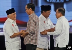 Indonesian Presidential candidates Joko Widodo, second left, his running mate Jusuf Kalla, right, Prabowo Subianto, second right and his running mate Hatta Rajasa, left, congratulate each other during a televised debate in Jakarta, Indonesia, Saturday, Ju