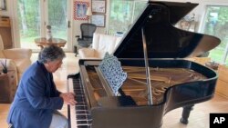 Robert Friedman plays a Steinway grand piano once owned by Thomas Edison, with possible bite marks from the inventor visible, on Sept. 28, 2022, in Woodstock, N.Y. (AP Photo/Michael Hill)