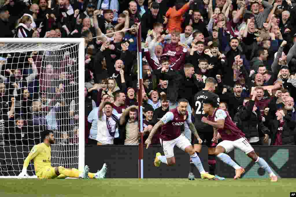 Aston Villa's Ollie Watkins, right, celebrates with Danny Ings after scoring his side's fourth goal past Brentford's goalkeeper David Raya, left, during the English Premier League soccer match between Aston Villa and Brentford at Villa Park in Birmingham, England.