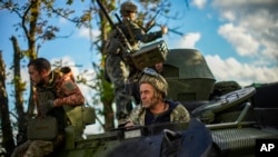 Wanajeshi wa Ukraine wakiwa wamepanda gari la kijeshi katika kijiji cha Shandrygolovo, karibu na Lyman, Ukraine. Okt 4, 2022