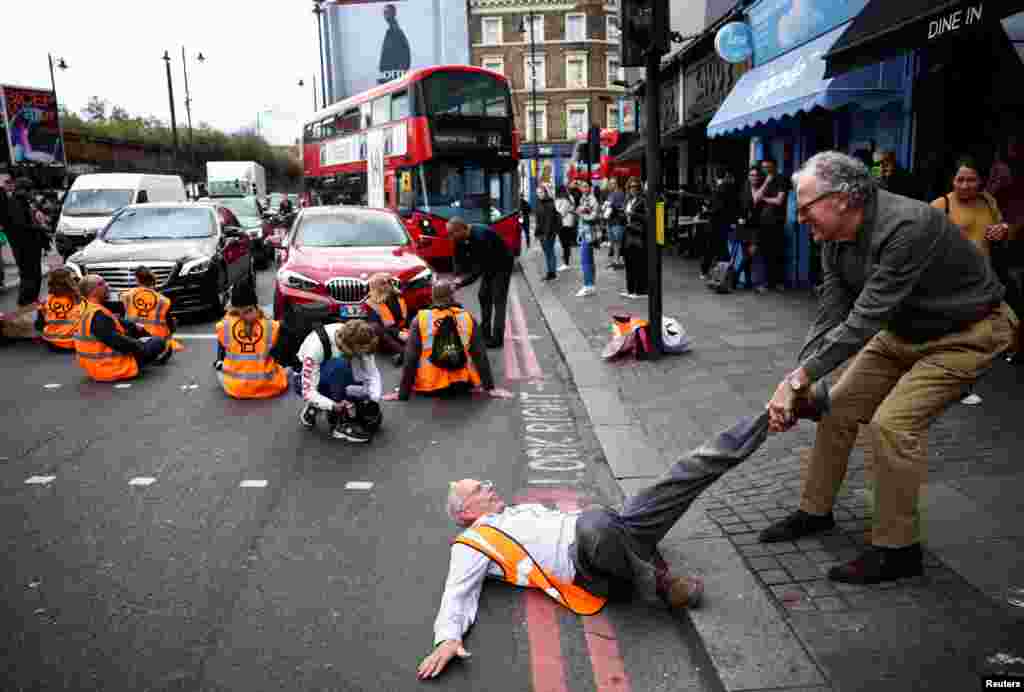 A member of the public drags an activist who is blocking the road during a "Just Stop Oil" protest, in London, Oct. 15, 2022.