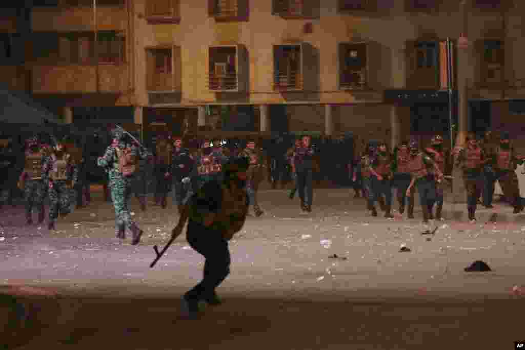 Security forces disperse government protesters during a demonstration to mark the third anniversary of the antigovernment demonstrations, in of Tahrir Square in Baghdad, Iraq.