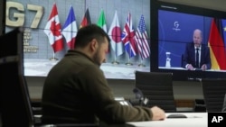 ប្រធានាធិបតី​អ៊ុយក្រែន​លោក Volodymyr Zelenskyy (ឆ្វេង) និង​អធិការបតី​អាល្លឺម៉ង់ លោក Olaf Scholz (ស្តាំ​លើ​អេក្រង់) ចូលរួម​សន្និសីទ​តាមអនឡាញ​របស់​​មេដឹកនាំ​នៃ​ក្រុម​ប្រទេស G-7 និង​អ៊ុយក្រែន​នៅ​ទីក្រុងកៀវ ប្រទេស​អ៊ុយក្រែន កាលពី​ថ្ងៃទី១១ ខែតុលា ឆ្នាំ២០២២។