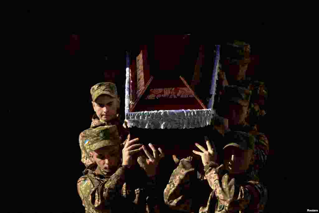 Ukrainian servicemen carry a coffin during a funeral ceremony for their brothers-in-arms Yurii Leliavskyi, Roman Vyshynskyi and Ihor Hadiak, who were killed while fighting against Russian troops, amid Russia's attack on Ukraine, in Lviv, Ukraine.