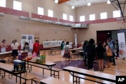 Residents attend an event hosted by Arizona State University graduate design students at Academia del Pueblo. (AP Photo/Matt York)
