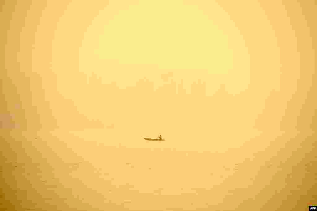 A man rows a boat in the waters of Dal Lake amid a foggy morning in Srinagar, India.