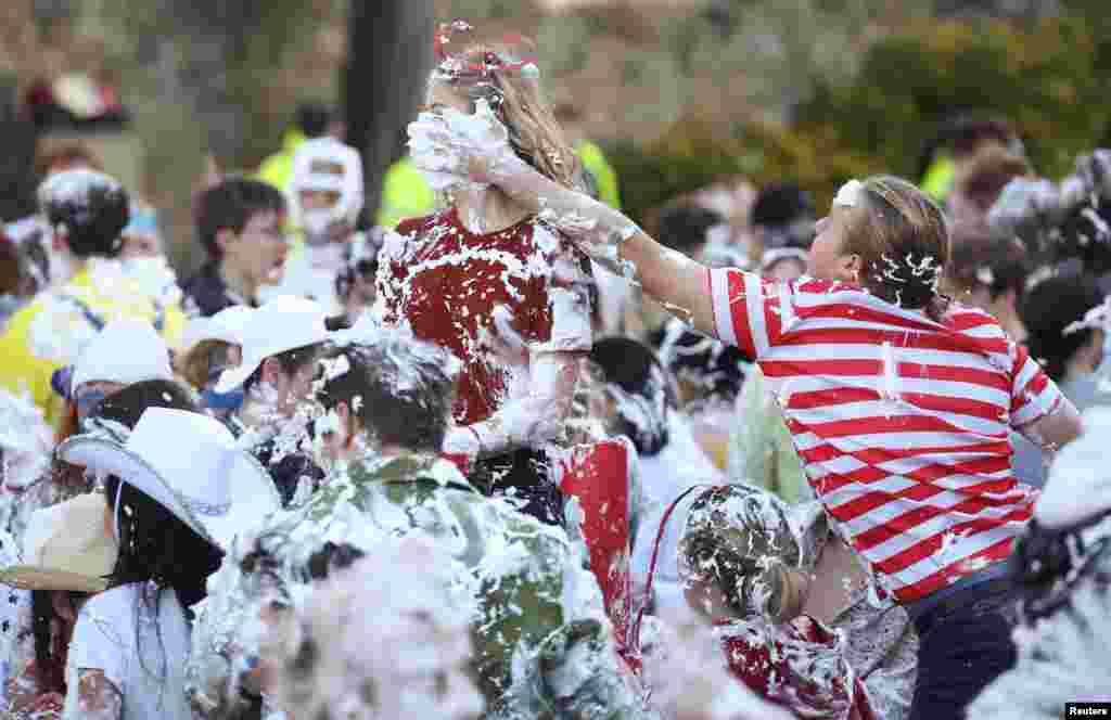 Students from St. Andrews University are covered in foam as they take part in the traditional "Raisin Weekend" in the Lower College Lawn, at St Andrews in Scotland, Britain.