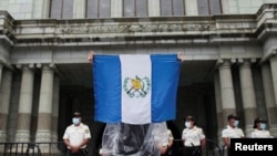 Un manifestante sostiene una bandera guatemalteca frente al Palacio Nacional de la Cultura durante una protesta contra lo que los manifestantes alegan es corrupción en el gobierno, en la Ciudad de Guatemala, el 11 de agosto de 2022.