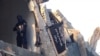 FILE - A fighter from the al-Qaida group in the Levant, Al-Nusra Front stands in a destroyed building in Yarmuk Palestinian refugee camp, south of Damascus, Sept. 22, 2014. 