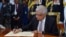 In this photo provided by the Sri Lankan President's Office, newly elected president Ranil Wickremesinghe, signs a document after taking the oath of office, in Colombo, Sri Lanka, July 21, 2022.