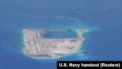 FILE - Fiery Cross Reef in the disputed Spratly Islands in the South China Sea is seen in this file photo. China says a military plane landed on the island Sunday.
