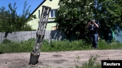 FILE - An emptied cluster munition container is seen stuck in the ground following a military strike, amid Russia's attack on Ukraine, on the outskirts of Kharkiv, Ukraine, June 10, 2022.