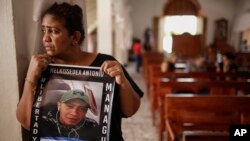 Martha Lorena Alvarado, madre de un manifestante antigubernamental encarcelado, sostiene un cartel con una imagen de su hijo en la Iglesia de San Miguel Arcángel en Masaya. Ella se ha unido a una huelga de hambre para exigir la libertad de sus familiares.