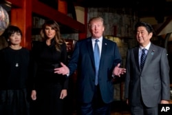U.S. President Donald Trump, accompanied by first lady Melania Trump, second from left, Japanese Prime Minister Shinzo Abe and his wife Akie Abe, left, speaks to members of the media before having a dinner at Ginza Ukai Tei restaurant, Nov. 5, 2017, in To