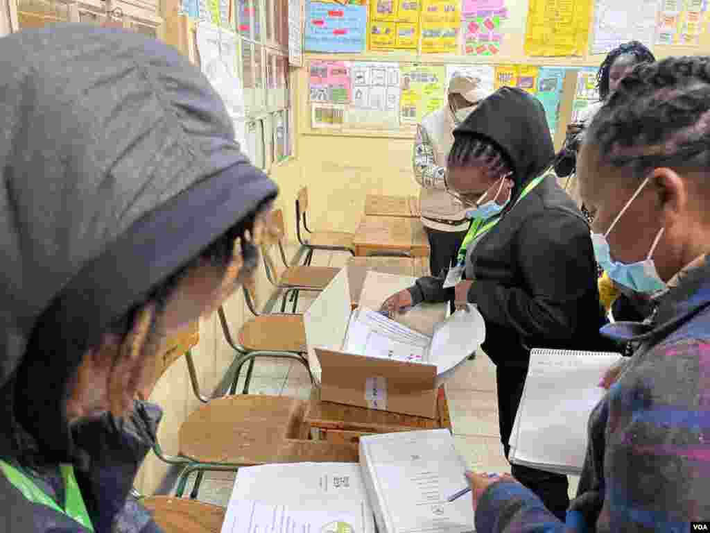 Maafisa wa vituo vya kupiga kura wakijiandaa kabla ya zoezi la kupiga kura kuanza Jumanne, katika shule ya msingi ya Westland, Nairobi, Kenya.