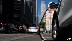 An electric vehicle is plugged into a charger in Los Angeles, Thursday, Aug. 25, 2022.(AP Photo/Jae C. Hong)