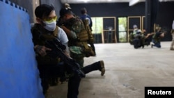 FILE - Tattoo artist, Su Chun holds an airsoft gun during a shooting lesson at the combat skill training company Polar Light, in New Taipei City, Taiwan, May 21, 2022.
