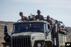 FILE - Ethiopian government soldiers ride in the back of a truck on a road near Agula, north of Mekelle, in the Tigray region of northern Ethiopia on May 8, 2021. (AP Photo/Ben Curtis, File)