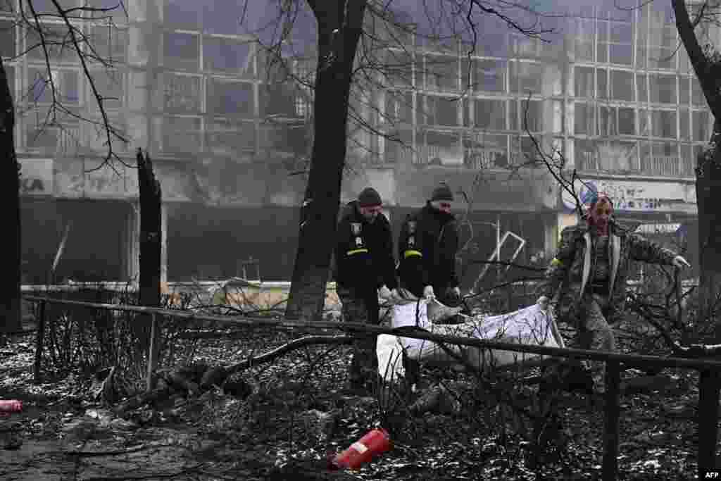 Police officers move the bodies of passersby killed in yesterday's airstrike that hit Kyiv's main television tower in Kyiv, Ukraine, March 2, 2022. 