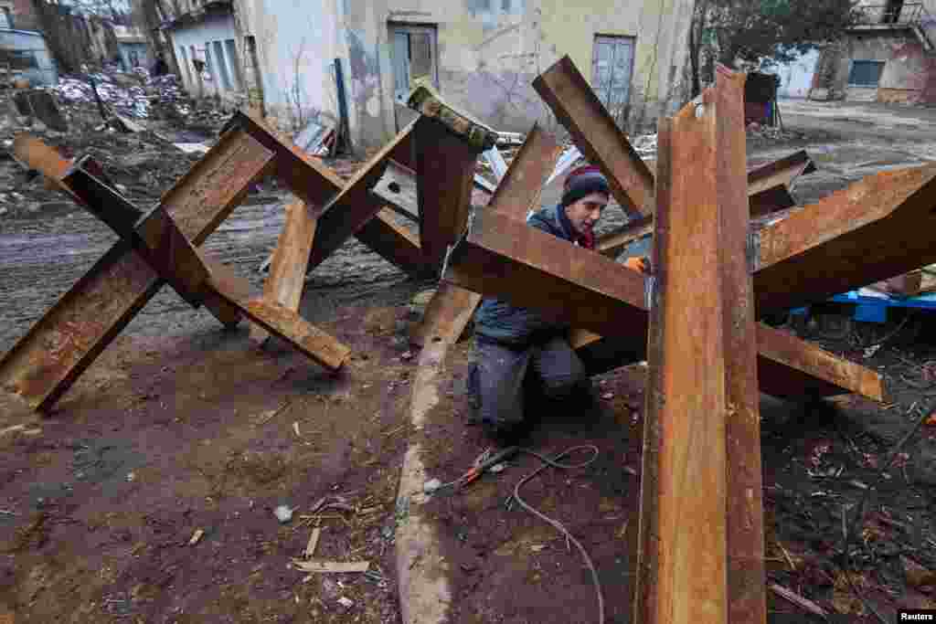 A local resident makes anti-tank obstacles to defend his and others cities, as Russia's invasion of Ukraine continues, in Lviv, Ukraine, March 2, 2022. 
