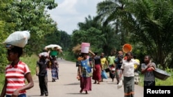 Perempuan Kongo membawa barang-barang mereka saat berjalan ke pasar di desa Kaniki-Kapangu dekat Mwene Ditu di Provinsi Kasai Oriental di Republik Demokratik Kongo, 15 Maret 2018. (Foto: Reuters)