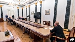 Russian President Vladimir Putin, right, leads a meeting on on economic issues in Moscow, Russia, Feb. 28, 2022.