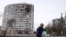 A man walks in front of a residential building damaged in yesterday's shelling in the city of Chernihiv on March 4, 2022.