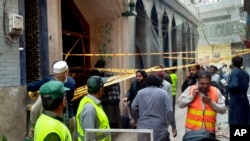 Rescue workers and volunteers gather at the site of bomb explosion in Peshawar, Pakistan, March 4, 2022.