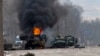 A Russian armored personnel carrier burns amid damaged and abandoned light utility vehicles after fighting in Kharkiv, Ukraine, Feb. 27, 2022. 