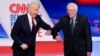 Bivši potpredsednik SAD Džozef Bajden i senator iz Vermonta Berni Sanders pozdravljaju se laktovima pred početak debate u studiju kablovske mreže CNN u Vašingtonu u nedelju 15. marta 2020. (Foto: AP/Evan Vucci)