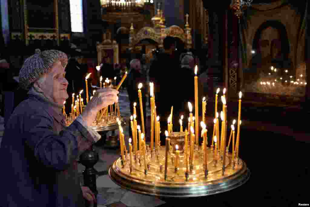 A Ukrainian Orthodox faithful lights a candle during the Sunday Mass at St. Volodymyr's Cathedral in Kyiv, Ukraine.
