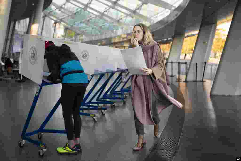 A voter moves to cast her ballot at an electronic counting machine at a polling site in the Brooklyn Museum, Nov. 8, 2022, in the Brooklyn borough of New York.