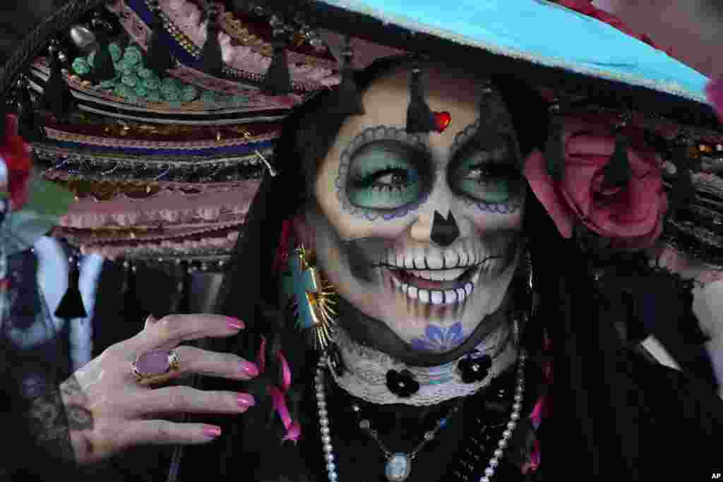 Dressed as a Catrina, a participant prepares to join the Florida Day of the Dead celebration, Nov. 5, 2022, in Fort Lauderdale, Florida.
