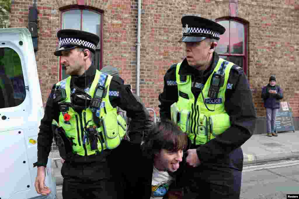 Police officers detain a man who threw an egg at King Charles during the king's visit to Micklegate bar in York, England.