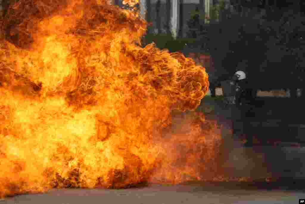 A Molotov cocktail explodes near riot police outside the Greek Parliament during clashes in Athens, Greece.&nbsp;Thousands of protesters are marching through the streets of Athens and the northern Greek city of Thessaloniki as public and some private sector workers walk off the job for a 24-hour general strike against price hikes.&nbsp;
