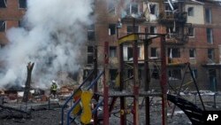 Ukrainian State Emergency Service firefighters work to extinguish a fire at the scene of a Russian shelling in the town of Vyshgorod outside Kyiv, Ukraine, Nov. 23, 2022.