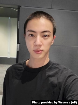 Jin of K-pop band BTS shows off freshly shaved hair on the K-pop social media platform Weverse, which was uploaded Dec. 11, 2022, ahead of his upcoming military conscription. (Weverse via AP)