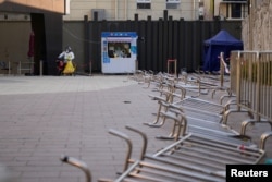 身穿防護服的工作人員在等候上海市民前來做新冠核酸檢測。 （2022年12月22日）