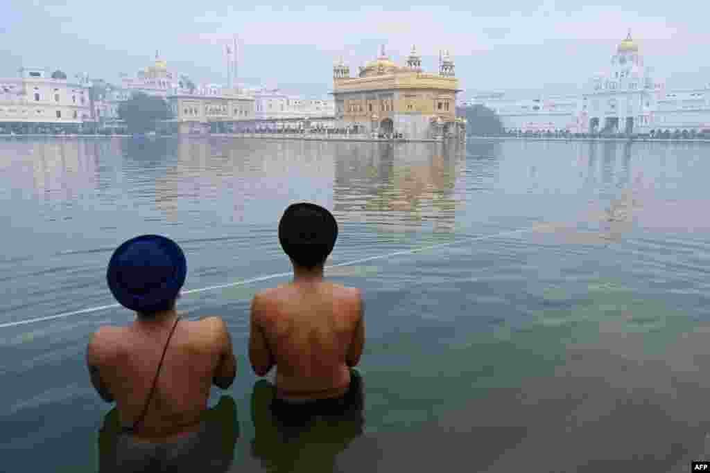 Los devotos toman un baño sagrado en sarovar en el Templo Dorado con motivo del Día de Año Nuevo en Amritsar el 1 de enero de 2023. [AFP]