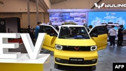 Pengunjung mengamati mobil listrik produksi pabrik mobil China Wuling dalam pameran mobil di Tangerang, 15 November 2021. (ADEK BERRY/AFP)