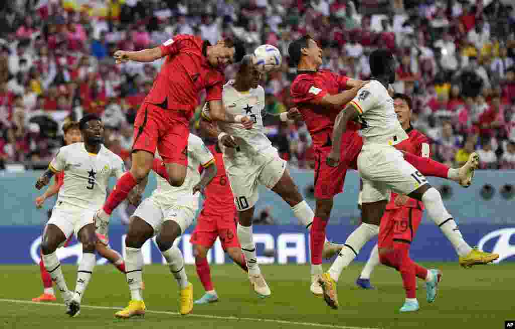 South Korea's Kim Min-jae, left, and Ghana's Andre Ayew, right, jump to head the ball during the World Cup group H soccer match between South Korea and Ghana, at the Education City Stadium in Al Rayyan, Qatar.