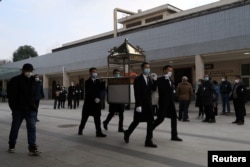 四川成都一個火葬場工作人員抬著一名逝者的骨灰盒走出火葬場。 (2022年12月28日)