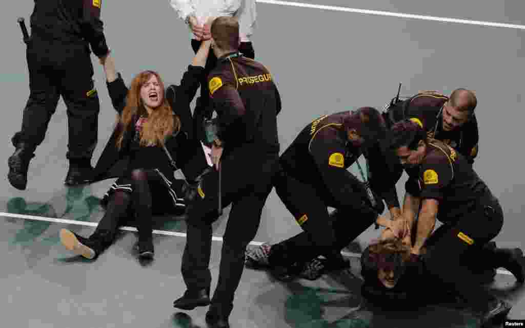 Climate protesters are detained after invading the court during the quarter final Coa Davis tennis match between Spain's Roberto Bautista-Agut and Croatia's Borna Coric in Malaga, Spain.