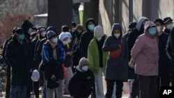 北京居民在一所醫院的發熱門診前大排長龍。（美聯社2022年12月11日照片）