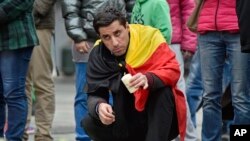 Un homme met une bougie pour les victimes des attentats, Place de la Bourse, Bruxelles, 23 mars 2016. 